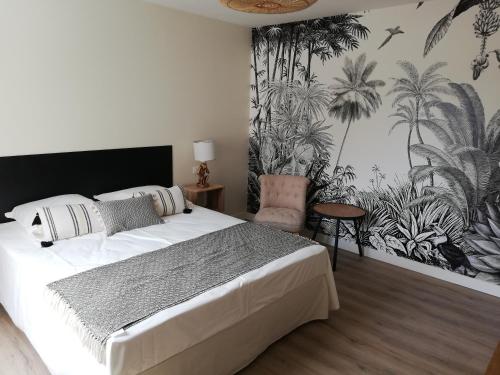 a bedroom with a large white bed and a chair at L'Angély - Chambres d'Hôtes in Niort