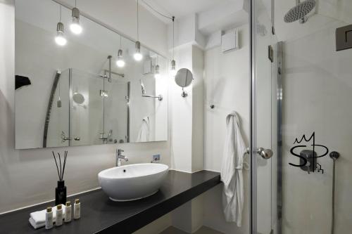 a white bathroom with a sink and a shower at Santorini Princess Spa Hotel in Imerovigli