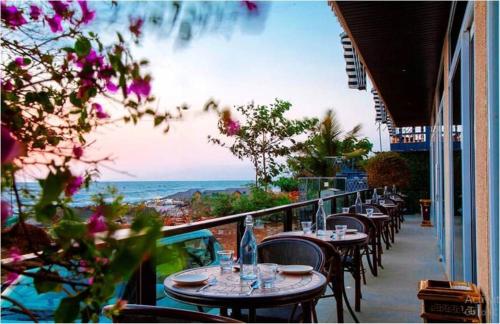 a balcony with tables and chairs with a view of the ocean at Royale Exotica, Goa in Calangute