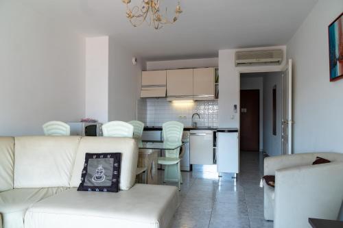 un salon avec un canapé blanc et une cuisine dans l'établissement Top Floor Apartment Santa Barbara, à Nice