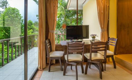 uma sala de jantar com mesa e cadeiras e uma varanda em Krabi Green Hill Pool Villas em Ban Nong Thale