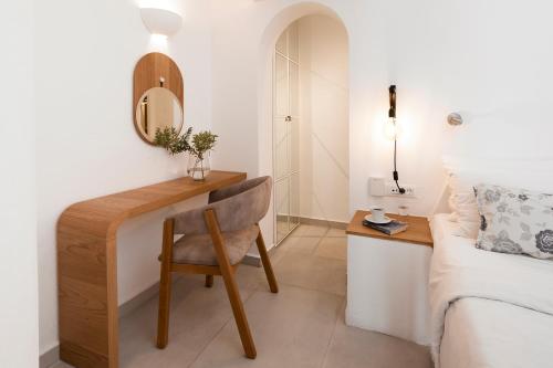 a bedroom with a desk and a chair next to a bed at Santorini Princess Spa Hotel in Imerovigli