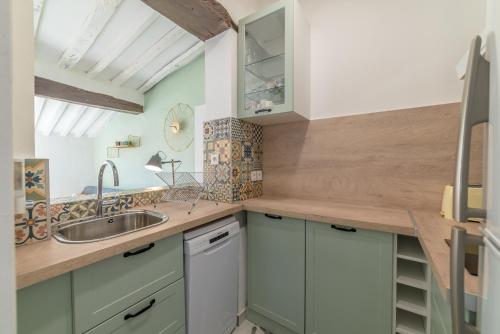a kitchen with green cabinets and a sink at Apt terrasse centre historique in Grasse