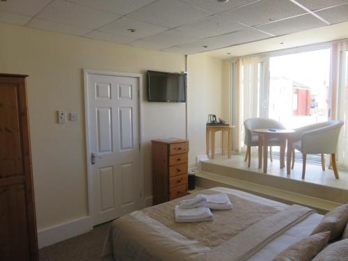 a bedroom with a bed and a table and a window at Stuart hotel in Blackpool