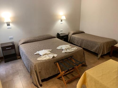 a room with two beds with towels on them at Hotel Select in Mar del Plata