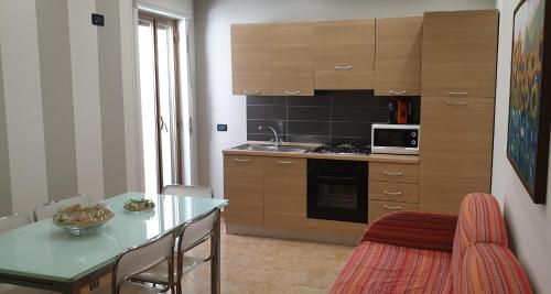 - une cuisine avec une table et un comptoir dans l'établissement Casa Vacanze L'isola del Relax, à Isola delle Femmine