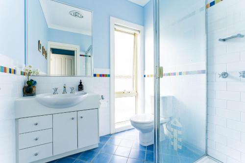 uma casa de banho com um lavatório, um WC e um chuveiro em WALKIN ON SUNSHINE - STROLL TO BEACH BREAK em Inverloch