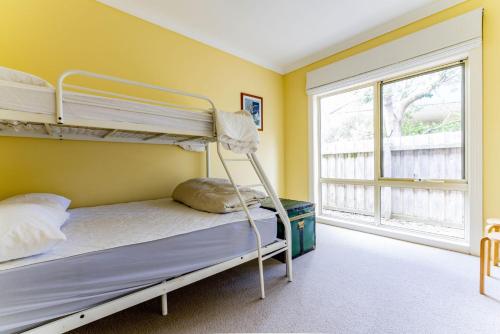 a bedroom with two bunk beds and a window at WALKIN' ON SUNSHINE in Inverloch
