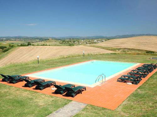 a swimming pool with a bunch of chairs around it at Holiday Home Capanna by Interhome in Casetta