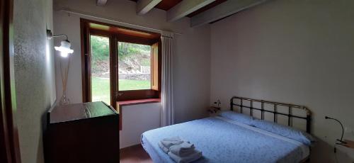 a bedroom with a bed and a sink and a window at El Serrat Turisme Rural in Planoles