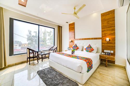 a bedroom with a bed and a desk and a window at Hotel Destination in Chandīgarh