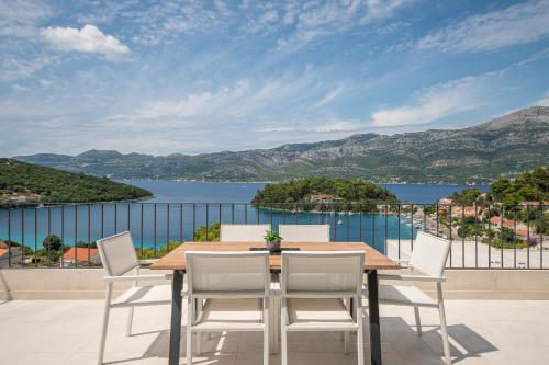 a table and chairs on a balcony with a view of the water at Korcula Hill in Korčula