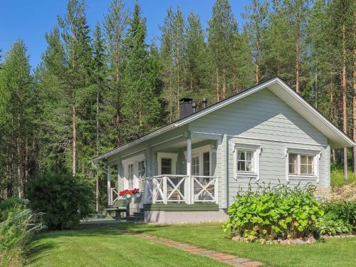 een klein wit huis midden in een tuin bij Holiday Home Sipukka by Interhome in Meltaus