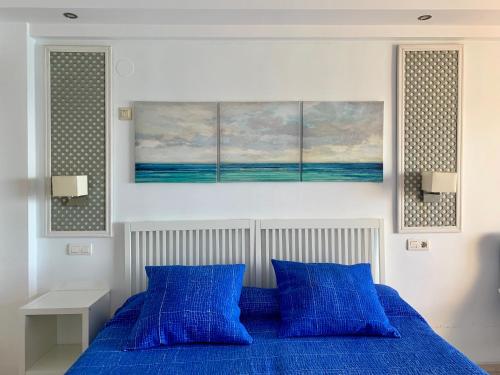 a bedroom with a blue bed with two blue pillows at CHINASOLYMAR LUXURY - Con Parking in Almuñécar