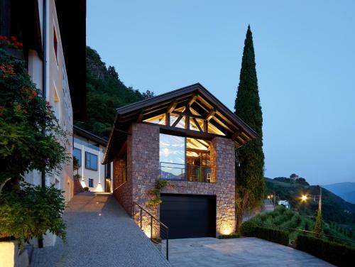 a brick house with a garage in front of a building at Pratenberg Wine Lodge in Merano