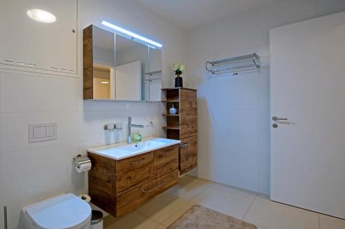 a bathroom with a sink and a toilet and a mirror at English Theater Apartment at Rathaus in Vienna