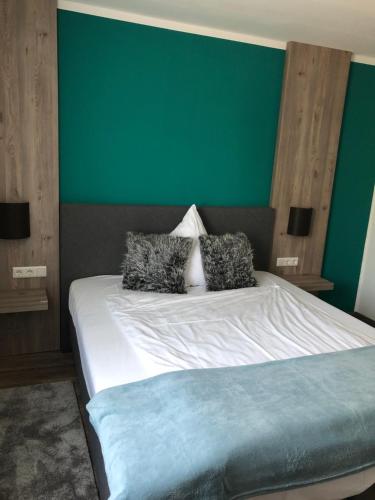 a bedroom with a bed with a green wall at Casalino in Wachtendonk