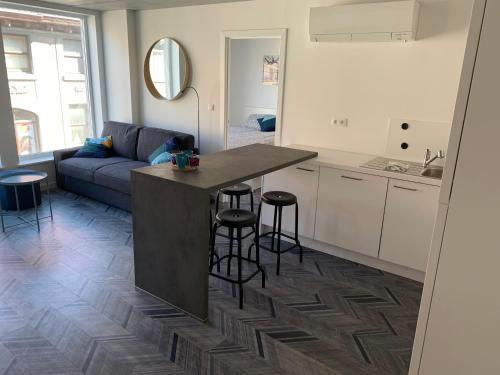 eine Küche und ein Wohnzimmer mit einem Tisch und Stühlen in der Unterkunft Gîte de Tournai - les beaux-arts in Tournai