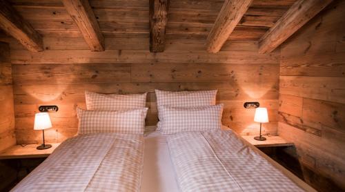 Кровать или кровати в номере Alpin Chalets Oberjoch - Luxus Unterkunft mit privatem SPA und Zugang zu 3000 qm SPA Panoramahotel Oberjoch