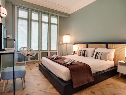 une chambre avec un grand lit et un bureau dans l'établissement Nestor&Jeeves - LAGOON PROMENADE - Central - Sea front, à Nice