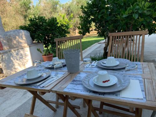 una mesa de madera con platos y platos. en B&B Medali, en Vernole