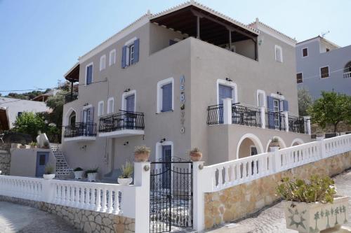 a large white house with a white fence at LEVANTA HOTEL SPETSES in Spetses