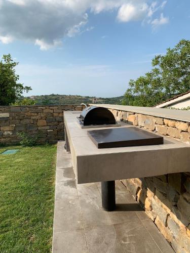 a concrete table with a pizza oven on a stone wall at Exceptional 5 Star villa with breathtaking views, Sauna and fitness studio in Momjan