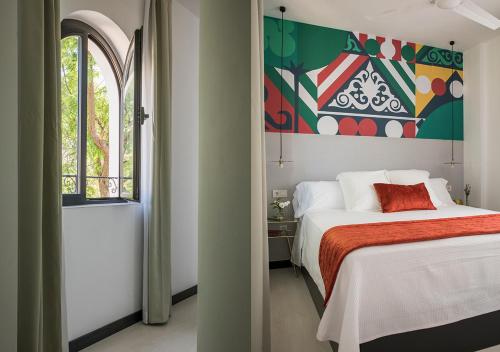 ein Schlafzimmer mit einem Bett und einem Wandgemälde in der Unterkunft Feria Pool & Luxury in Sevilla