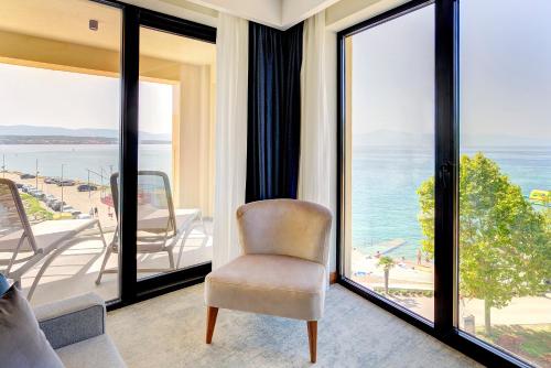 a room with a chair and a view of the ocean at Luxury Hotel Riva in Malinska
