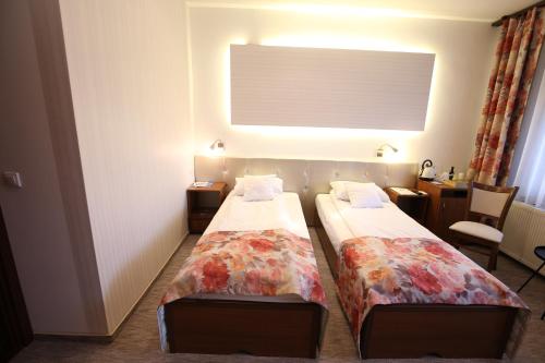 a hotel room with two beds in a room at Pension Ferdinand Panzio in Sfântu-Gheorghe