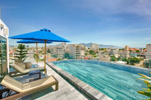uma piscina com um guarda-chuva azul num edifício em Meliora Hotel & Apartment em Da Nang