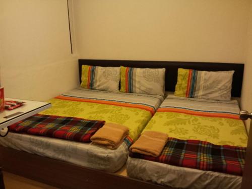 two beds sitting next to each other in a bedroom at Fastbook Bendera Home 8 & 10pax in Ayer Itam