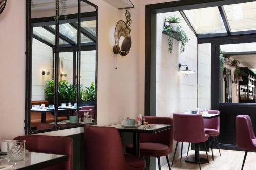 a restaurant with tables and chairs and a window at Hotel Bastille Speria in Paris