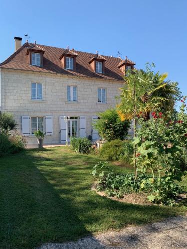 a house with a palm tree in front of it at La Massonnière Gîte et chambres d'hôtes in Mondion