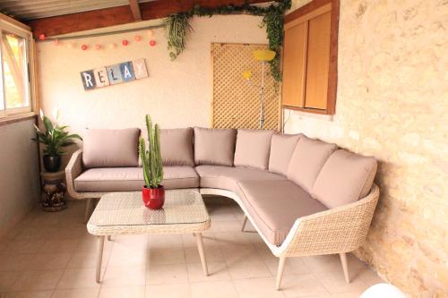 a couch in a room with a cactus on a table at La Massonnière Gîte et chambres d'hôtes in Mondion