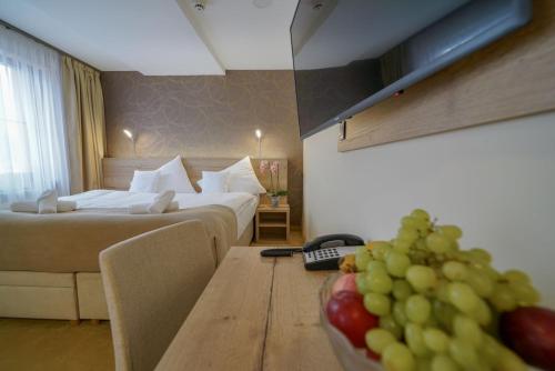 a hotel room with two beds and a bowl of fruit on a table at Grand Hotel BELLEVUE in Smokovce