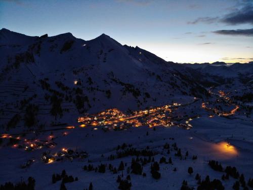 a view of a town in the snow at night at Andi's Skihotel in Obertauern