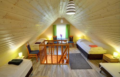 Habitación grande con 2 camas, mesa y sillas. en Pensjonat Olympia w Przesiece, en Przesieka
