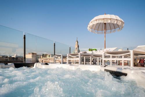 a hot tub with an umbrella in the water at Dream House Pompei in Pompei