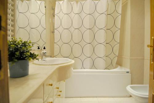 Down Town Apartment - EXPO27 في لشبونة: حمام مع حوض وحوض استحمام ومرحاض