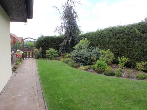 a garden with a brick walkway and green grass at Ubytování Benátky u Litomyšle in Litomyšl