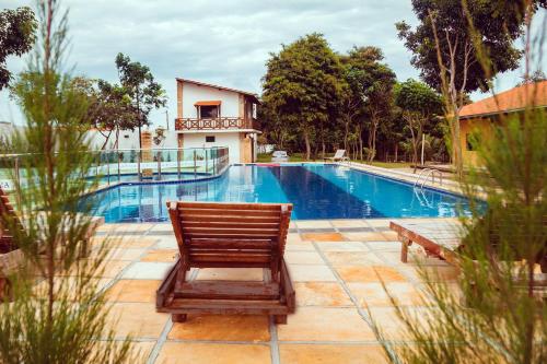 a wooden chair sitting next to a swimming pool at Hotel Ibiapaba in Tianguá