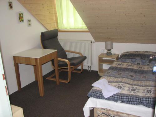 a bedroom with a bed and a desk and a chair at Ubytování Benátky u Litomyšle in Litomyšl