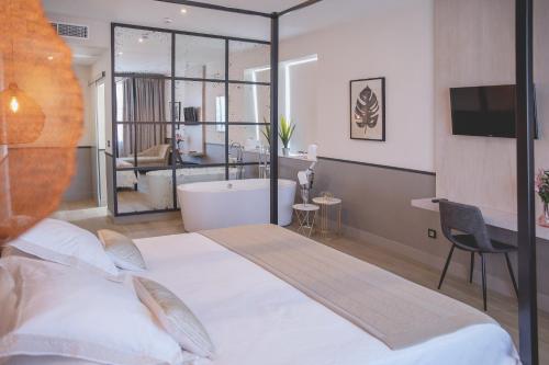 a bedroom with a large bed and a bath tub at Hotel Paraiso Granada in Moraleda de Zafayona