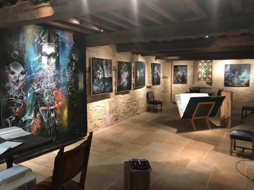 a room with a bunch of pictures on the wall at Auberge de l'Abbatiale in Auberive