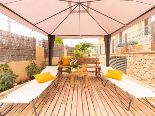 um pátio com uma mesa e um guarda-chuva em Holiday Home Cap Roig by Interhome em L'Ampolla