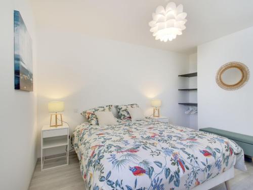 une chambre avec un lit avec un couvre-lit fleuri dans l'établissement Apartment Domaine d'Augustin Apt B01 by Interhome, à Saint-Malo
