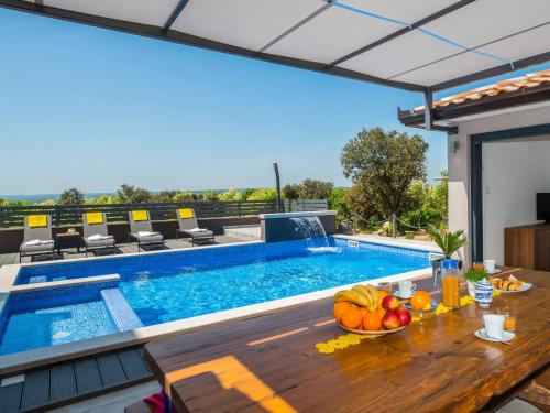 コロマチノにあるVilla A-R-T- by Interhomeのスイミングプール、テーブル(フルーツ付)が備わるヴィラです。