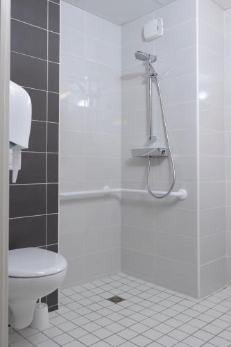 a bathroom with a shower and a toilet at Ekho Hotel Grenoble Nord Saint Egrève in Saint-Égrève