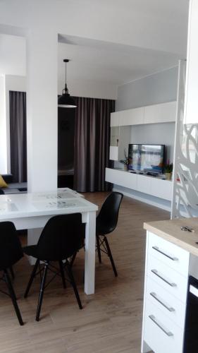 a kitchen and dining room with a white table and chairs at Maestro in Wyszków